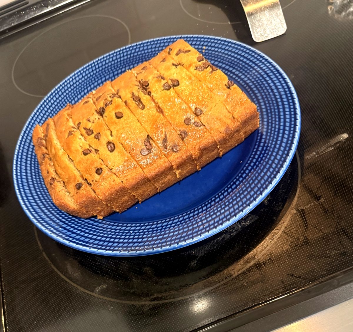Sliced chocolate chip banana bread loaf on a blue plate